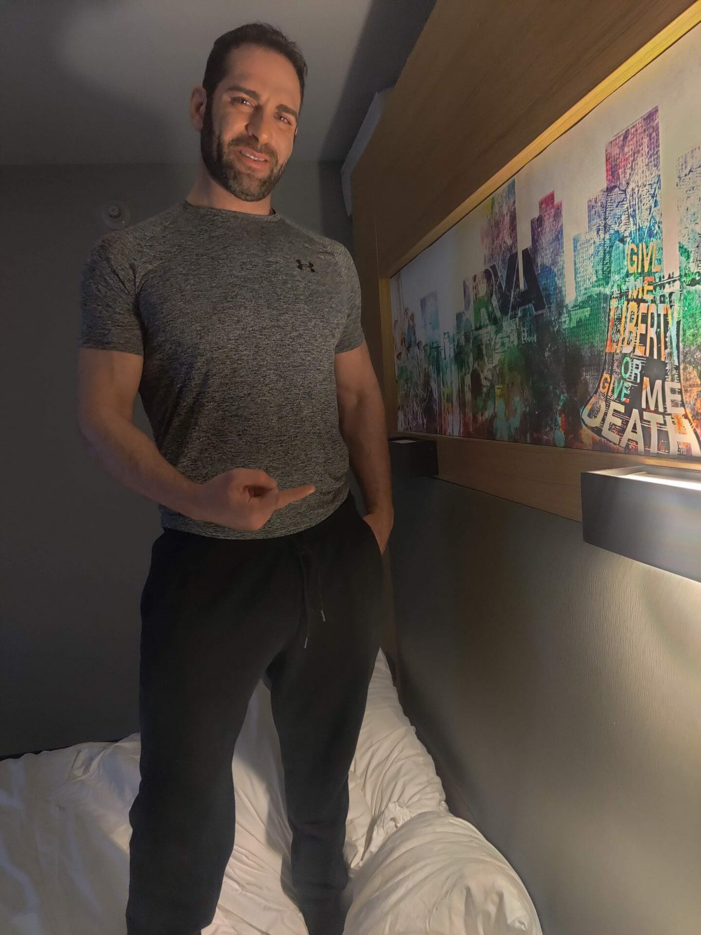 Israel Joffe standing beside a colorful painted New York cityscape artwork